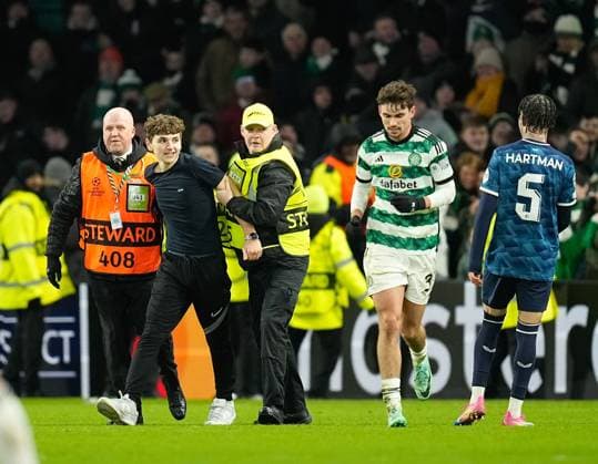 A Celtic fan on the pitch tries for a selfie picture with Matt O Riley of Celtic after Gustaf Lagerbielke of Celtic scored to give Celtic a 2-1 lead. Celtic v Feyenoord, UEFA Champions League, Group E, Football, Celtic Park, Glasgow, UK - 13 Dec 2023 EDITORIAL USE ONLY No use with unauthorised audio, video, data, fixture lists, club league logos or live services. Online in-match use limited to 120 images, no video emulation. No use in betting, games or single club league player publications.  Copyright: xStuartxWallace Shutterstockx 14254242bx