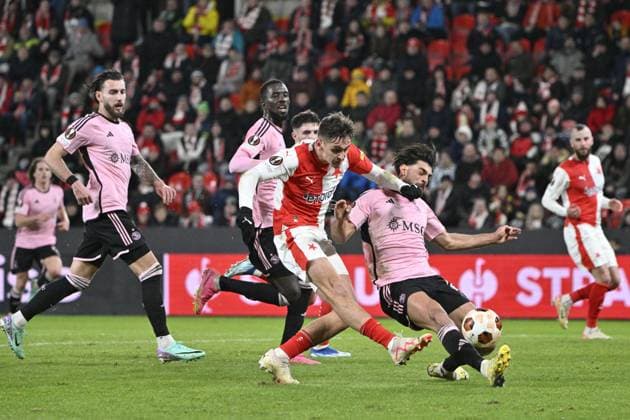 Mojmir Chytil of Slavia, left, shots a goal during the UEFA Europa League 6th round Group G football match Slavia Praha vs Servette Geneva in Prague, Czech Republic, December 14, 2023. At right is Nicolas Vouilloz of Servette. (CTKxPhoto VitxSimanek) CTKPhotoP2023121407915  CTKPhotoP2023121407915