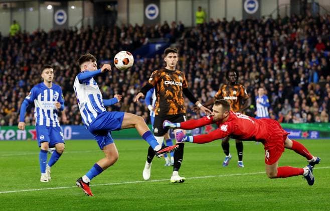 Pau Lopez of Marseille makes a save from Jack Hinshelwood of Brighton & Hove Albion. Brighton & Hove Albion v Marseille, UEFA Europa League, Group A, Football, American Express Community Express Stadium, Brighton, UK - 14 Dec 2023 EDITORIAL USE ONLY No use with unauthorised audio, video, data, fixture lists, club league logos or live services. Online in-match use limited to 120 images, no video emulation. No use in betting, games or single club league player publications.  Copyright: xJamesxMarsh Shutterstockx 14254279r