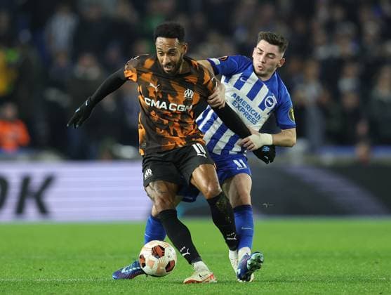 Brighton and Hove, England, 14th December 2023. Pierre-Emerick Aubameyang of Olympique de Marseille and Billy Gilmour of Brighton and Hove Albion challenge for the ball during the UEFA Europa League match at the AMEX Stadium, Brighton and Hove. Picture credit should read: Paul Terry Sportimage EDITORIAL USE ONLY. No use with unauthorised audio, video, data, fixture lists, club league logos or live services. Online in-match use limited to 120 images, no video emulation. No use in betting, games or single club league player publications. SPI-2802-0010