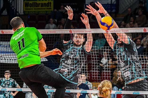 from left Sebastian Lucas Rösler Bitterfeld Wolfen, 11 with a smash against the block of Petr Spulak Powervolleys Düren, 4 and Frixos Kotsakis Powervolleys Düren, 7 , Action, Action, Game scene, 27 12 2023, Düren Germany , Volleyball, 1 Bundesliga Men, SWD Powervolleys Düren BC Bitterfeld Wolfen xmhx