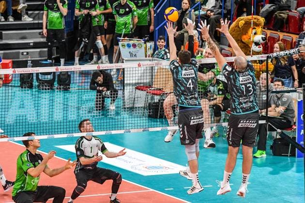 Ben Simon Bonin Bitterfeld Wolfen, 16 , 2 v r , during a smash against Petr Spulak Powervolleys Düren, 4 and Sebastian Gevert Powervolleys Düren, 13 , action, action, game scene, 27 12 2023, Düren Germany , Volleyball, 1 Bundesliga Men, SWD Powervolleys Düren BC Bitterfeld Wolfen xmhx