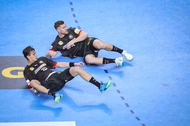 26 01 2024, EHF EURO 2024, European Mens Handball Championship, Lanxess Arena in Cologne, semi-final, Germany Denmark Johannes Golla Germany and Julian Köster Germany lie on the playing field Floor North Rhine-Westphalia Germany