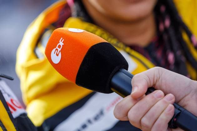 Symbol photo ZDF DEU Germany Saxony Altenberg, 18 02 2024, BMW IBSF World Cup Bobsleigh in Altenberg, SachsenEnergie Eiskanal, two-man bobsleigh, A ZDF television journalist interviews athletes and holds a microphone with the ZDF logo in his hand AF_Bob_Altenberg_47048