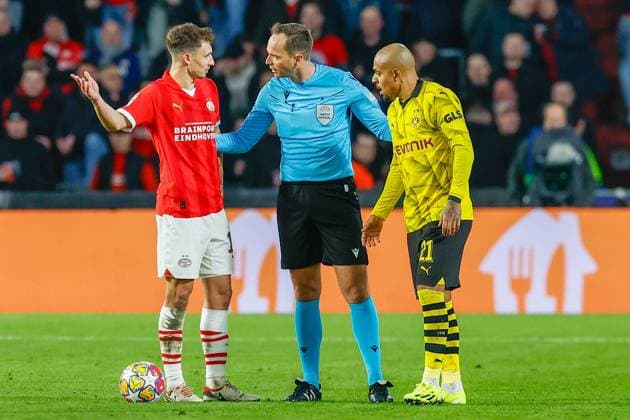 EINDHOVEN, 20-02-2024, Philips Stadium, UEFA Champions League season 2023 24, match between PSV and Borussia Dortmund, PSV player Olivier Boscagli , Referee Srdjan Jovanovic and Borussia Dortmund player Donyell Malen PSV - Borussia Dortmund  x24344534x Copyright: