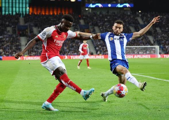 Porto, Portugal, 21st February 2024. Bukayo Saka of Arsenalcrosses the ball past Evanilson of FC Porto during the UEFA Champions League match at the Estadio do Dragao, Porto. Picture credit should read: David Klein Sportimage EDITORIAL USE ONLY. No use with unauthorised audio, video, data, fixture lists, club league logos or live services. Online in-match use limited to 120 images, no video emulation. No use in betting, games or single club league player publications. SPI-2957-0032