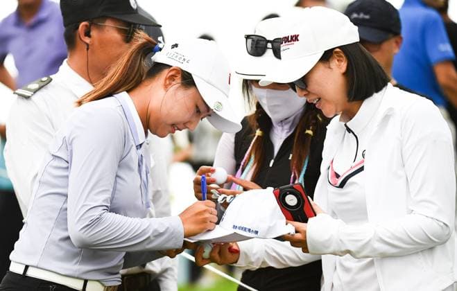 (240307) -- LINGSHUI, March 7, 2024 -- Wang Xinying (L) of China signs for fans after the first round of the Blue Bay LPGA, Golf Damen golf tournament in Lingshui, south China s Hainan Province, March 7, 2024. ) (SP)CHINA-HAINAN-LINGSHUI-GOLF-BLUE BAY LPGA (CN) YangxGuanyu 