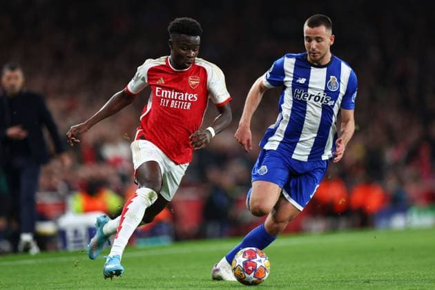 Bukayo Saka of Arsenal chased by Nico Gonzalez of FC Porto Arsenal v Porto, UEFA Champions League, Round of 16, Second Leg, Football, Emirates Stadium, London, UK - 12 Mar 2024 EDITORIAL USE ONLY No use with unauthorised audio, video, data, fixture lists, club league logos or live services. Online in-match use limited to 120 images, no video emulation. No use in betting, games or single club league player publications. Copyright: xSimonxDael Shutterstockx 14384999ac