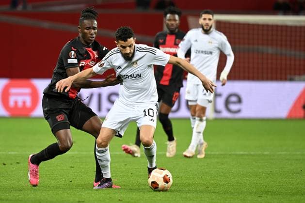 (240315) -- LEVERKUSEN, March 15, 2024 -- Odilon Kossounou (L) of Bayer 04 Leverkusen vies with Abdellah Zoubir of Qarabag FK during the UEFA Europa League Round of 16 second leg match between Bayer 04 Leverkusen and Qarabag FK in Leverkusen, Germany, March 14, 2024. (Photo by Xinhua) (SP)GERMANY-LEVERKUSEN-FOOTBALL-UEFA EUROPA LEAGUE-LEVERKUSEN VS QARABAG UlrichxHufnagel 