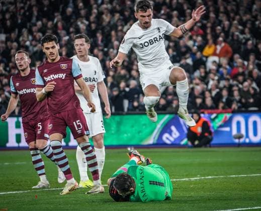 Soccer UEFA Europa League 2023 2024, Round of 16, West Ham United SC Freiburg, London Olympic Stadium Freiburgs Maximilian Philipp leaps over West Ham goalkeeper Lukasz Fabianski London Olympic Stadium England Copyright: xJoeranxSteinsiekx