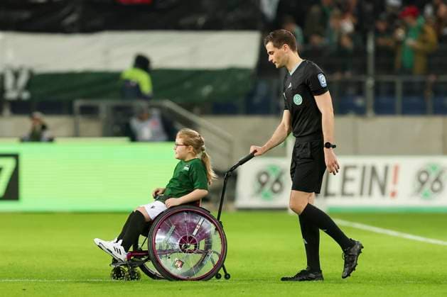 A disabled girl in a wheelchair is driven onto the pitch by referee Dr. Max Burda, 2 Bundesliga, Hannover 96 vs 1 FC Kaiserslautern, HDI Arena, 16 03 2024, Hannover, Germany