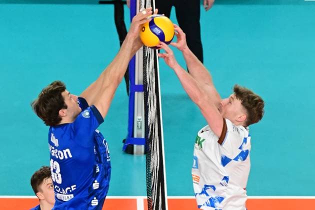 Volleyball I Men I 2023 2024 I Bundesliga I Playoffs I Quarterfinals I Game 2 I SVG Lüneburg WWK Volleys Herrsching I 23 3 2024 Birds-eye view Matthew Knigge 13, SVG Lüneburg holds the ball with Eric Burggräf 9, WWK Volleys Herrsching over the net with the happier ending for SVG Lüneburg Lüneburg LKH Arena Niedersachsen Germany Copyright: xLobeca AndreasxHannigx