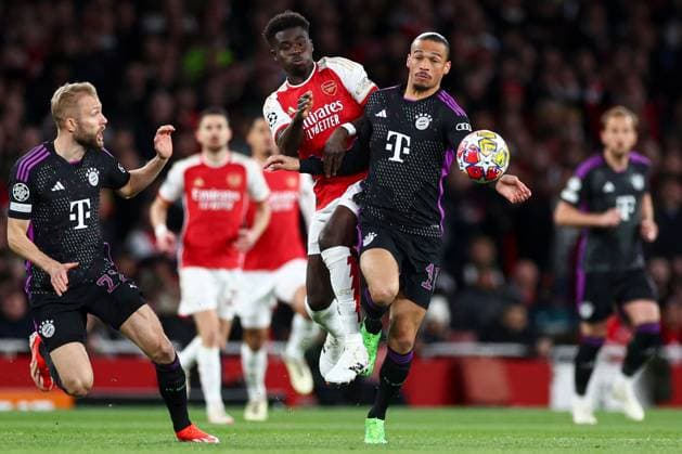Bukayo Saka of Arsenal battles with Leroy Sanà of Bayern Munich (R) under pressure from Raphaël Guerreiro of Bayern Munich (L) Arsenal v Bayern Munich, UEFA Champions League, Quarter Final, First Leg, Football, Emirates Stadium, London, UK - 09 Apr 2024 EDITORIAL USE ONLY No use with unauthorised audio, video, data, fixture lists, club league logos or live services. Online in-match use limited to 120 images, no video emulation. No use in betting, games or single club league player publications. Copyright: xSimonxDael Shutterstockx 14424047t