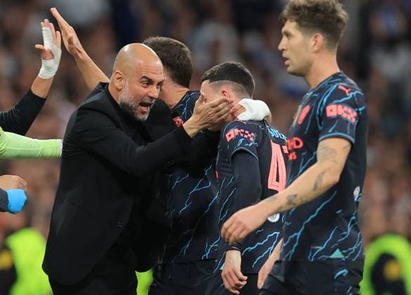 Madrid, Spain, 9th April 2024. Phil Foden of Manchester City (C) celebrates with Josep Guardiola coach of Manchester City after scoring his teams second goal during the UEFA Champions League match at the Santiago Bernabau, Madrid. Picture credit should read: Paul Terry Sportimage EDITORIAL USE ONLY. No use with unauthorised audio, video, data, fixture lists, club league logos or live services. Online in-match use limited to 120 images, no video emulation. No use in betting, games or single club league player publications. SPI-3066-0075