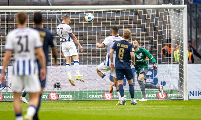 Berlin, 12 04 2024, Soccer, 2 Bundesliga, Matchday 29, Hertha BSC Hansa Rostock, Olympiastadion Berlins Palko Dardai M scores to 1 0 against goalkeeper Markus Kolke of Hansa Rostock DFL regulations and DFB regulations prohibit any use of photographs as image sequences and or quasi video, Foto Andreas Gora Hertha BSC Hansa Rostock