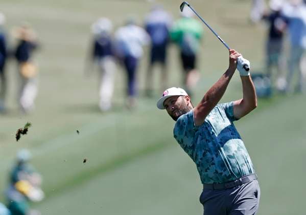 Spain s Jon Rahm hits his approach shot on the first hole in the second round of the Masters Tournament at Augusta National Golf Club in Augusta, Georgia on Friday, April 12, 2024.  AUG20240412115 JOHNxANGELILLO