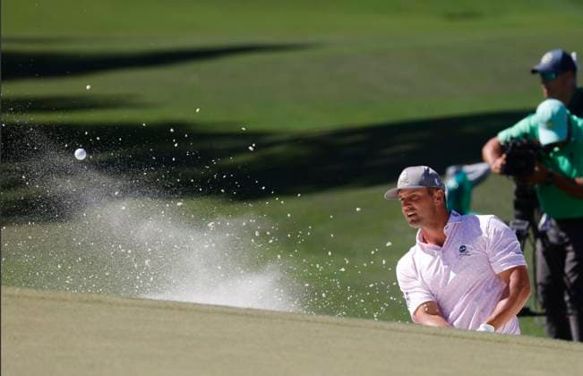 Bryson DeChambeau hits out of a bunker on the seventh hole during the third round of the Masters Tournament at Augusta National Golf Club in Augusta, Georgia on Saturday, April 13, 2024.  AUG20240413537 TANNENxMAURY