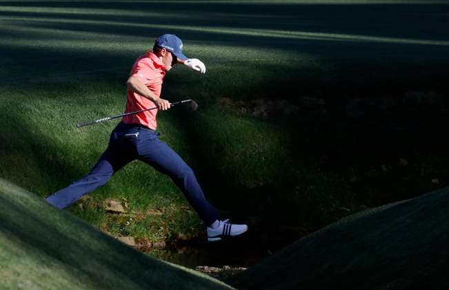 Denmark s Nicolai Hojgaard leaps over over Ray s Creek after taking a drop on the thirteenth hole during the third round of the Masters Tournament at Augusta National Golf Club in Augusta, Georgia on Saturday, April 13, 2024.  AUG20240413138 JOHNxANGELILLO