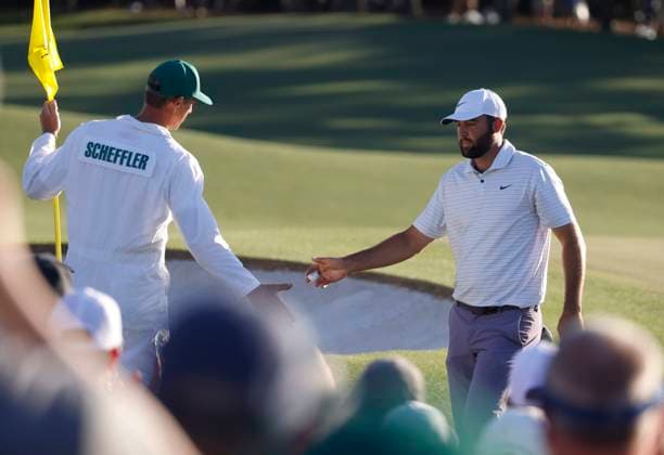 Scottie Scheffler is congratulated by his caddie Ted Scott after sinking a birdie putt on the eighteenth hole during the third round of the Masters Tournament at Augusta National Golf Club in Augusta, Georgia on Saturday, April 13, 2024. Scheffler ended the day in the lead at seven-under-par.  AUG20240413559 TANNENxMAURY