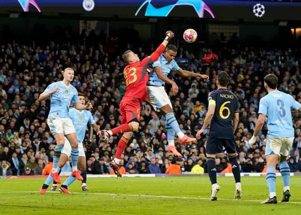 Manchester, England, 17th April 2024. Andriy Lunin of Real Madrid punches clear as Manuel Akanji of Manchester City attempts to make contact with the ball during the UEFA Champions League Quarter Final 2nd Leg match at the Etihad Stadium, Manchester. Picture credit should read: Andrew Yates Sportimage EDITORIAL USE ONLY. No use with unauthorised audio, video, data, fixture lists, club league logos or live services. Online in-match use limited to 120 images, no video emulation. No use in betting, games or single club league player publications. SPI-3082-0072