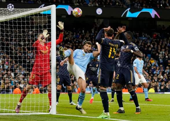 Andriy Lunin of Real Madrid pushes the ball away as Ruben Dias of Manchester City comes in Manchester, England, 17th April 2024. during the UEFA Champions League Quarter Final 2nd Leg match at the Etihad Stadium, Manchester. Picture credit should read: Andrew Yates Sportimage EDITORIAL USE ONLY. No use with unauthorised audio, video, data, fixture lists, club league logos or live services. Online in-match use limited to 120 images, no video emulation. No use in betting, games or single club league player publications. SPI-3082-0081