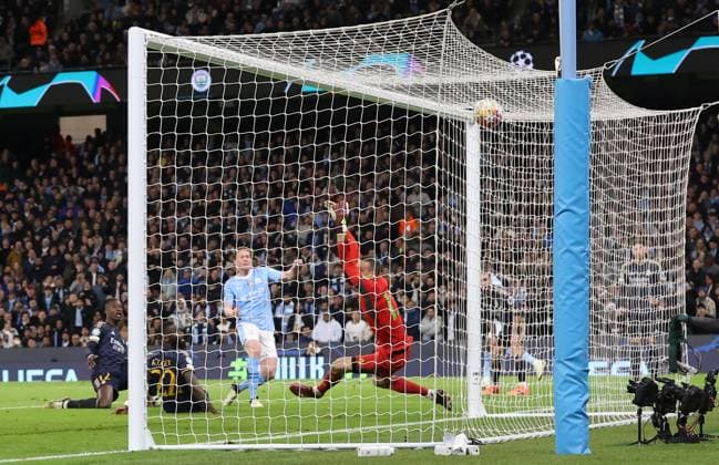 17th April 2024; Etihad Stadium, Manchester, England; Champions League Football, Quarter Final, Manchester City versus Real Madrid; Kevin de Bruyne of Manchester City beats Andriy Lunin of Real Madrid to level the score at 1-1 after 76 minutes  ActionPlus12631439 DavidxBlunsden