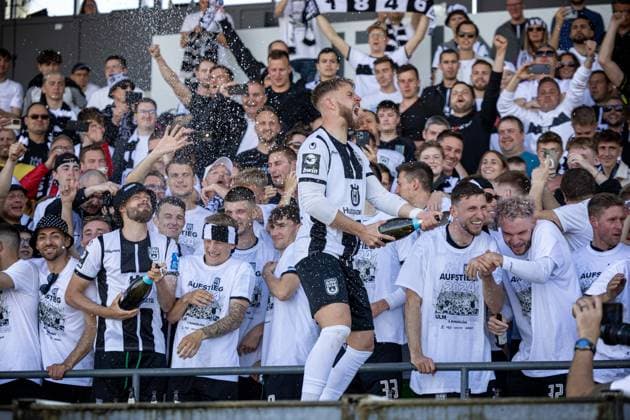 The players of SSV Ulm celebrate the promotion to Bundesliga 2 together with their fans on the grandstand Johannes Reichert SSV Ulm 1846, 05 with the champagne ¨¨GER, SSV Ulm 1846 Fussball vs FC Viktoria Koeln, Fußball, 3 Liga, 36 Spieltag, Spielzeit 2023 2024, 04 05 2024, ¨DFB DFL regulations prohibit any use of photographs as image sequences and or quasi video ,¨ SSV Ulm 1846 Fussball FC Viktoria Koeln , Fußball, 3 Liga, 36 Spieltag, Spielzeit 2023 2024, 04 05 2024 Ulm Copyright: xDennisxDuddek xEibnerxPressefotox EP_DDK