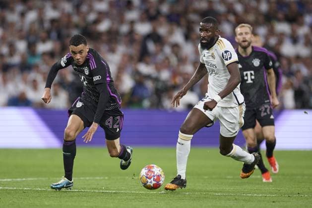 Jamal Musiala of FC Bayern Munich compete for the ball with Antonio Rudiger of Real Madrid CF during the UEFA Champions League match between Real Madrid and Bayern Munich at Santiago Bernabeu Stadium on May 8, 2024 in Madrid, Spain. (Photo by: LGM) FOOTBALL : Real Madrid vs Bayern Munich- UEFA Champions League - 08 05 2024 LGM Panoramic 