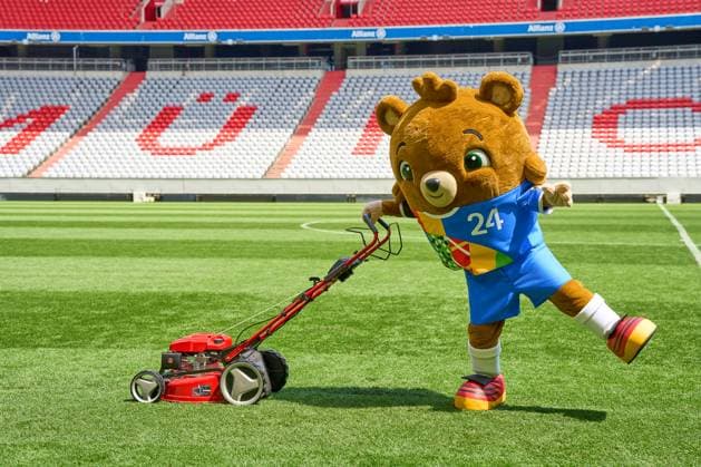 Das Maskottchen der UEFA EURO 2024, ein Teddybär der Albärt heißt. Maskottchen der Europameisterschaft mäht symbolisch den Rasen des Spielfeldes der Allianzarena in München