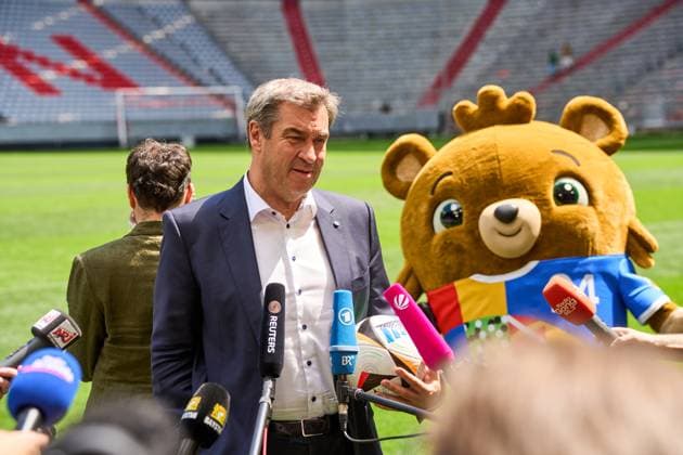 Ministerpräsident Dr. Markus Söder (CSU) auf dem Fußball Spielfeld der Allianz Arena in München. Er gibt ein Interview, neben Ihm steht das Maskottchen der EM 2024, Albärt