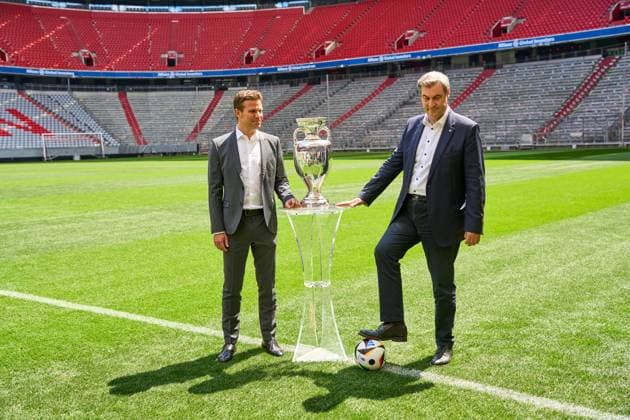 Ministerpräsident Dr. Markus Söder (CSU) zusammen mit FIFA Schiedsrichter Felix Brych auf dem Fußball Spielfeld der Allianz Arena in München, neben dem Henri-Delaunay-Pokal der UEFA EURO 2024