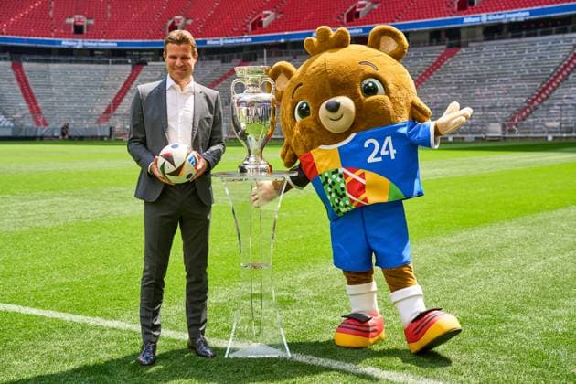 FIFA Schiedsrichter Felix Brych neben dem Henri-Delaunay-Pokal der UEFA EURO 2024 auf dem Fußball Spielfeld der Allianz Arena in München. EM Maskottchen Albärt neben dem Pokal