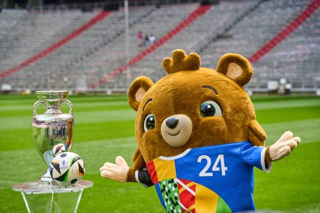 Themenbild Fußball EURO 2024: Maskottchen der Europameisterschaft Albärt steht auf dem Spielfeld der Allianz Arena zusammen mit dem offiziellen Spielball von Adidas und dem Henri-Delaunay-Pokal der UEFA EURO 2024