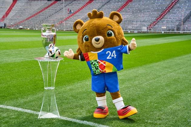 Themenbild Fußball EURO 2024: Maskottchen der Europameisterschaft Albärt steht auf dem Spielfeld der Allianz Arena zusammen mit dem offiziellen Spielball von Adidas und dem Henri-Delaunay-Pokal der UEFA EURO 2024