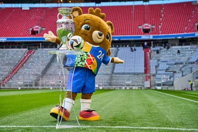 Themenbild Fußball EURO 2024: Maskottchen der Europameisterschaft Albärt steht auf dem Spielfeld der Allianz Arena zusammen mit dem offiziellen Spielball von Adidas und dem Henri-Delaunay-Pokal der UEFA EURO 2024