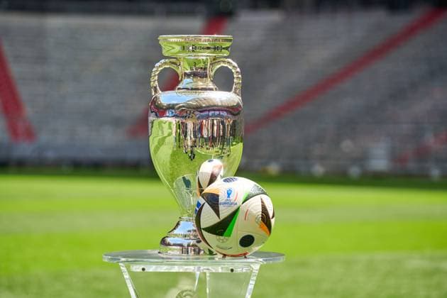 Themenbild Fußball EURO 2024: Henri-Delaunay-Pokal der UEFA EURO 2024 zusammen mit dem offiziellen Spielball der Europameisterschaft von Adidas auf dem Spielfeld der Allianz Arena in München