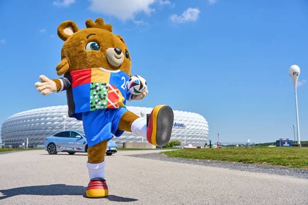 Maskottchen der EM 2024 bzw. Fußball-Europameisterschaft vor der Allianz Arena, mit einem BYD Seal Elektroauto als Sponsor und einem Adidas Spielball im Trikot