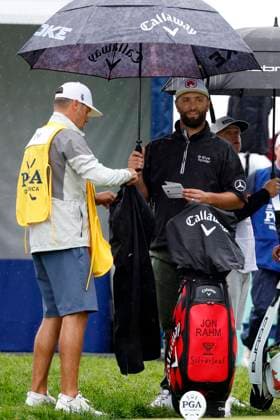 LOUISVILLE, KY - MAY 17: Jon Rahm and caddie Adam Hayes stand under an umbrella on the No. 10 tee box preparing rain gear prior to beginning the second round of the PGA, Golf Herren Championship, May 17, 2024, at Valhalla Golf Club in Louisville, Kentucky.(Photo by Matthew Maxey Icon Sportswire) GOLF: MAY 17 PGA Championship EDITORIAL USE ONLY Icon240517012