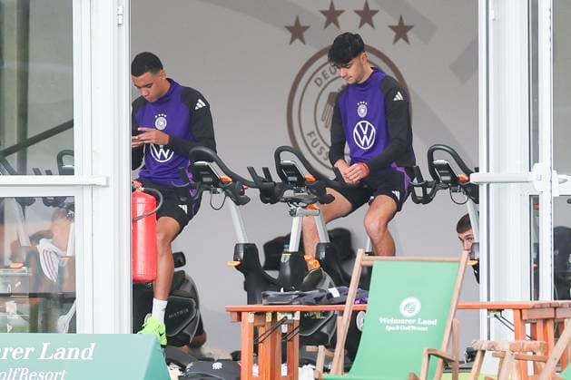 Jamal Musiala and Aleksandar Pavlovic sitting in the tent on the bike, training camp of the German national team, Blankenhain, Germany