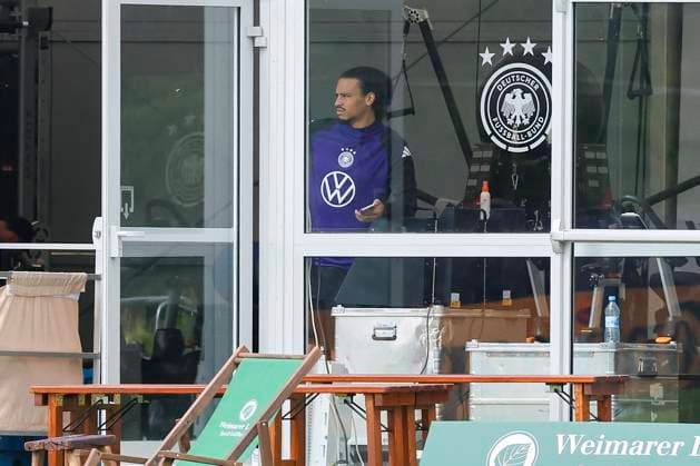 Leroy Sane watches the training from the tent, training camp of the German national team, Blankenhain, Germany