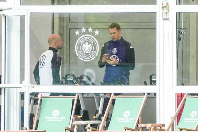 Goalkeeper Goalie Manuel Neuer Germany Germany trains on the ergometer in the fitness tent on his first day at the training camp and checks his fitness levels with his cell phone and trainer Blankenhain 29 05 2024 Training camp for the German national team in preparation for the European Championship, Golf Resort Weimarer Land