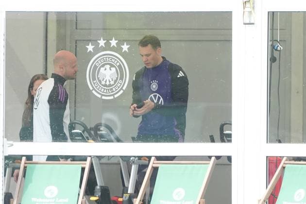 Goalkeeper Goalie Manuel Neuer Germany Germany trains on the ergometer in the fitness tent on his first day at the training camp and checks his fitness levels with his cell phone and trainer Blankenhain 29 05 2024 Training camp for the German national team in preparation for the European Championship, Golf Resort Weimarer Land