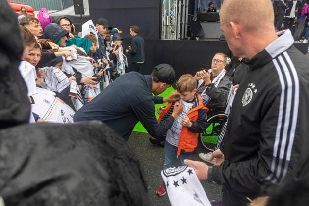 Report 31 05 2024 Arrival party of the German mens national team at adidas in Herzogenaurach in pouring rain Jamal Musiala with little fan Herzogenaurach Bavaria Germany