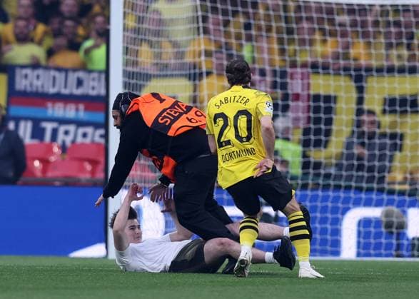 London, England, 1st June 2024. One of three pitch invaders makes it onto the pitch delaying the game Marcel Sabitzer of Borussia Dortmund helps stop him during the UEFA Champions League final match at Wembley Stadium, London. Picture credit should read: David Klein Sportimage EDITORIAL USE ONLY. No use with unauthorised audio, video, data, fixture lists, club league logos or live services. Online in-match use limited to 120 images, no video emulation. No use in betting, games or single club league player publications. SPI-3169-0069