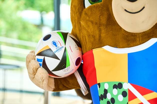 Das offizielle Maskottchen der Fußball UEFA EURO 2024 Albärt posiert mit dem Fussballliebe Spielball bei einem Pressetermin im Olympiapark in München