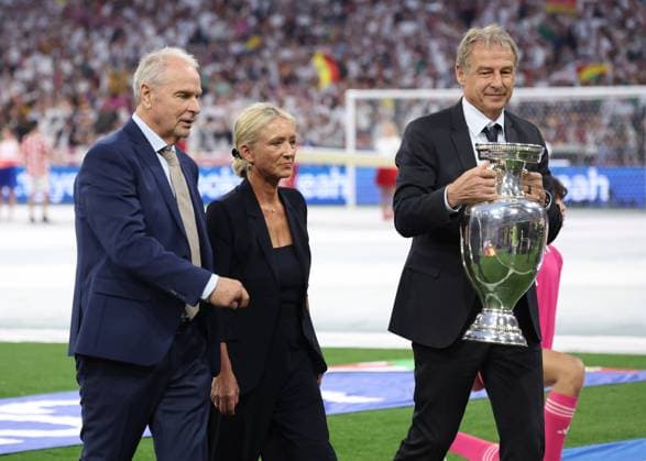 Munich, Germany, 14th June 2024. Heidi Beckenbauer daughter of Franz and Jurgen Klinsmann walk out to place the trophy on the plinth before the UEFA European Championships match at Allianz Arena, Munich. Picture credit should read: David Klein Sportimage EDITORIAL USE ONLY. No use with unauthorised audio, video, data, fixture lists, club league logos or live services. Online in-match use limited to 120 images, no video emulation. No use in betting, games or single club league player publications. SPI-3194-0054