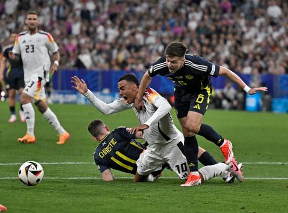 14 06 2024, Football UEFA EURO 2024, Preliminary round, Matchday 1, Opening match Germany Scotland, at Fußball Arena München Jamal Musiala Germany is fouled by Ryan Christie Scotland , Jamal Musiala Germany and Kieran Tierney Scotland