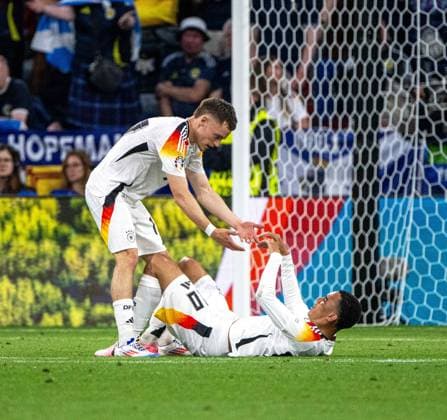 Football, men, season 2023 24, Euro 2024 Group A 1 matchday in Munich, Germany Scotland, v l Florian Wirtz Germany helps Jamal Musiala Germany up, 14 06 2024, Copyright: xMatthiasxKochx