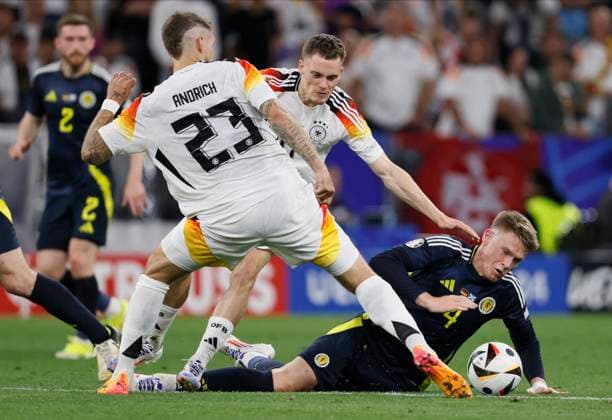 Germany v Scotland: Group A - UEFA EURO, EM, Europameisterschaft,Fussball 2024 Robert Andrich, Florian Wirtz of Germany and Scott McTominay of Scotland challenge during the UEFA EURO 2024 group stage match between Germany and Scotland at Munich Football Arena on June 14, 2024 in Munich, Germany. Munich Munich Football Arena Germany Germany Copyright: xRichardxSellers Sportsphoto APLx 14040504