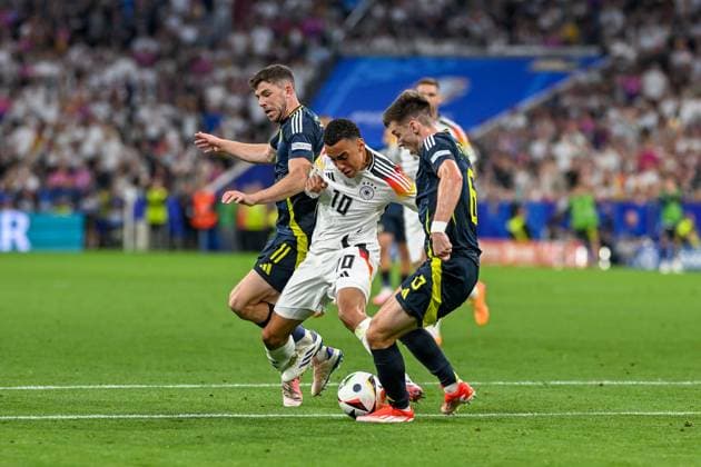 Euro 2024 Germany Scotland on 14 06 2024 at the Allianz Arena in Munich Ryan Christie of Scotland in a duel against Jamal Musiala Germany and Kieran Tierney of Scotland MT